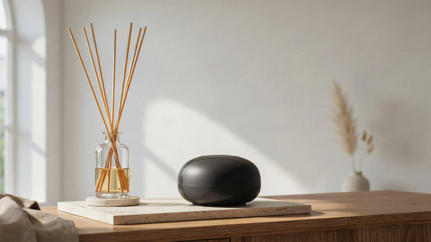 Reed diffuser and waterless electric diffuser styled in a refined living room.
